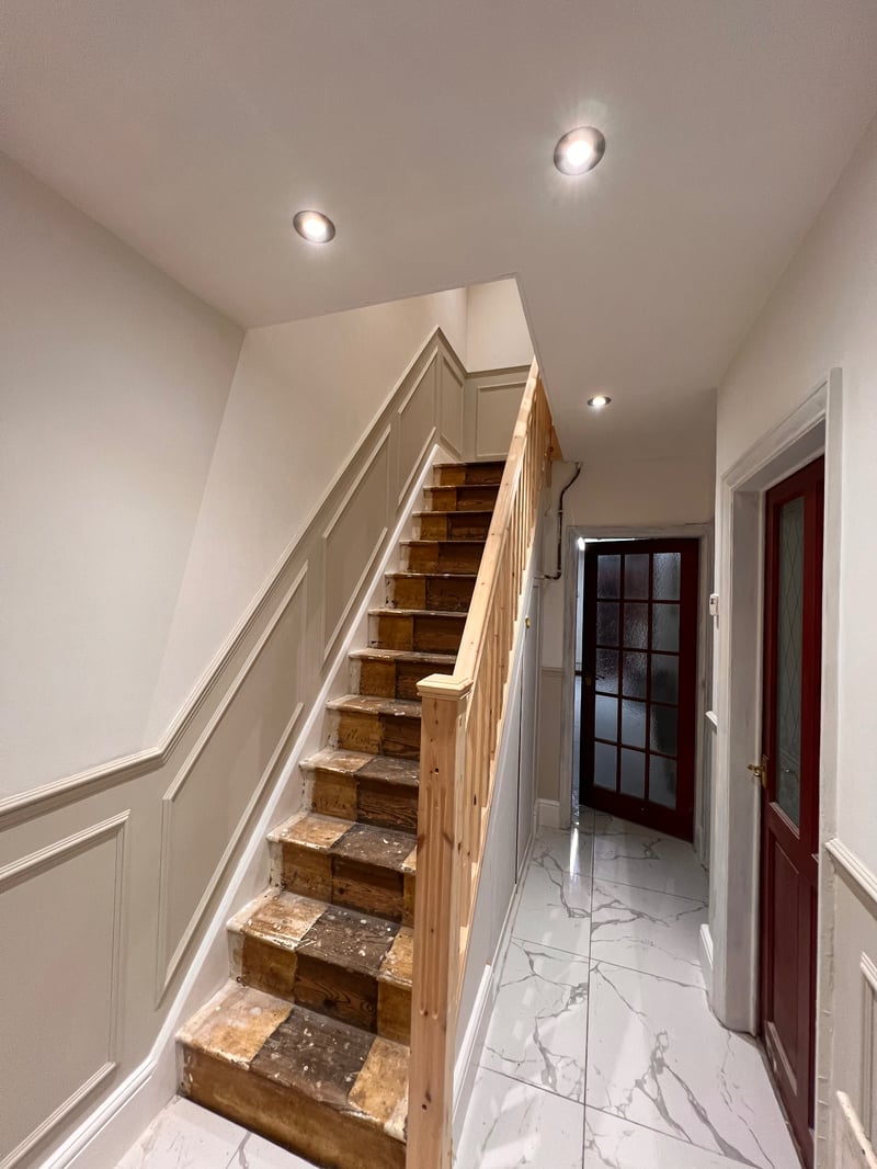 Completed hallway with white walls, decorative wall panelling and new spotlights
