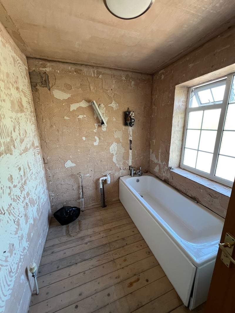 Bathroom stripped back to bare plaster and floorboards during renovation