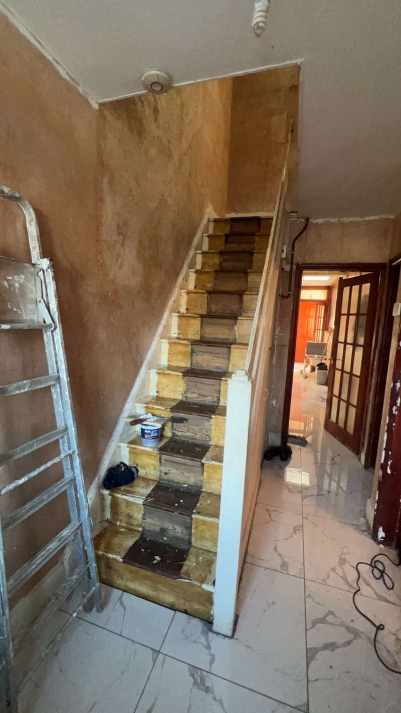 Hallway and staircase stripped back to bare plaster before renovation